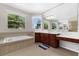 Bright bathroom featuring a soaking tub beneath a window and a spacious vanity area at 2801 Boat Cove Cir, Kissimmee, FL 34746