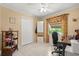 Bright bedroom with a ceiling fan, closet, and a window with floral curtains, perfect for an office space at 2933 N Chickasaw Trl, Orlando, FL 32817
