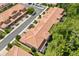 Aerial view of clay tiled townhouses with green landscaping, and a neighborhood parking area at 299 Terracina Dr, Sanford, FL 32771