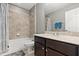 Bathroom features a shower over tub, vanity with dark cabinets, and neutral tile and paint at 299 Terracina Dr, Sanford, FL 32771