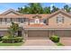 Inviting two-story townhouse features a red tile roof, two-car garage, and beautifully maintained landscaping at 299 Terracina Dr, Sanford, FL 32771