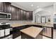 Well-equipped kitchen features dark cabinets, granite countertops, stainless appliances and an island at 299 Terracina Dr, Sanford, FL 32771