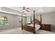 Main bedroom with tray ceiling, four poster bed, carpet and windows at 299 Terracina Dr, Sanford, FL 32771