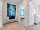Hallway with ocean artwork leading to a bedroom with bright blue curtains and furniture at 3635 Fort Mellon Ln, Sanford, FL 32773