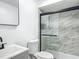 Modern bathroom featuring marble-tiled shower with a sleek glass enclosure and black trim at 43 Lake Court Loop, Ocala, FL 34472