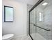 Bright bathroom featuring a marble-tiled shower with sleek glass enclosure and black trim at 43 Lake Court Loop, Ocala, FL 34472