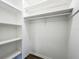 Walk-in closet with white walls and shelves, and dark wood-look flooring at 43 Lake Court Loop, Ocala, FL 34472