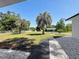 Landscaped front yard featuring lovely palm trees, lush green lawn, and a welcoming walkway leading to the home at 43 Lake Court Loop, Ocala, FL 34472