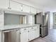 Kitchen with stainless steel dishwasher and fridge, marble countertops and white cabinets at 43 Lake Court Loop, Ocala, FL 34472