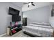Modern bedroom with dark furniture, multiple large screen televisions, ceiling fan, and modern decor at 4313 Gumbo Limbo Dr, Orlando, FL 32822