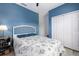 Cozy bedroom featuring a blue accent wall, a comfortable bed, and ample closet space at 4313 Gumbo Limbo Dr, Orlando, FL 32822