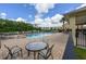 Community pool with lounge chairs and tables, surrounded by lush landscaping and natural scenery at 4313 Gumbo Limbo Dr, Orlando, FL 32822