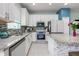 Modern kitchen features a stylish backsplash, granite countertops, white cabinets, and stainless-steel appliances at 4313 Gumbo Limbo Dr, Orlando, FL 32822