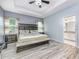 Comfortable main bedroom featuring wood floors, a tray ceiling, and an attached bathroom at 4313 Gumbo Limbo Dr, Orlando, FL 32822