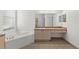 Bright bathroom featuring a soaking tub and a spacious vanity with ample storage at 4520 Barrister Dr, Clermont, FL 34711