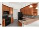 Kitchen featuring wood cabinets, black appliances, and tile backsplash at 4520 Barrister Dr, Clermont, FL 34711