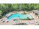 Aerial view of community pool, surrounded by lounge chairs, tables, and lush landscaping at 4520 Barrister Dr, Clermont, FL 34711