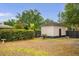 Detached garage sits near a hedge row in the partially shaded backyard at 490 Shoreview Ave, Winter Park, FL 32789