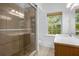 Modern bathroom features a glass shower and vanity with a sink, illuminated by natural light from a window at 490 Shoreview Ave, Winter Park, FL 32789