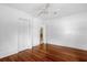 Well-lit bedroom with hardwood floors, closet doors, and a ceiling fan for cozy and functional living at 490 Shoreview Ave, Winter Park, FL 32789