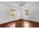 Light-filled bedroom with hardwood floors, two windows, and a ceiling fan for a comfortable living space at 490 Shoreview Ave, Winter Park, FL 32789