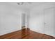 Bedroom featuring hardwood floors, white walls and trim, and an open doorway, leading to another room at 490 Shoreview Ave, Winter Park, FL 32789