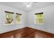 Sunny bedroom with gleaming hardwood floors, two large windows, and ceiling fan offering a bright and airy feel at 490 Shoreview Ave, Winter Park, FL 32789