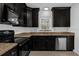Updated kitchen featuring dark cabinetry, stainless steel dishwasher, and modern appliances at 490 Shoreview Ave, Winter Park, FL 32789