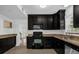 Kitchen with black cabinets, granite countertops, and stainless steel appliances at 490 Shoreview Ave, Winter Park, FL 32789
