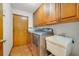 Well-lit laundry room featuring stainless steel washer and dryer, utility sink, and ample cabinet space for storage at 513 Sabal Trail Cir, Longwood, FL 32779
