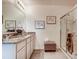 Bathroom featuring double vanity, granite countertops, glass shower, and neutral decor at 5169 Masser Rd, St Cloud, FL 34772