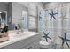 Bright bathroom with a white vanity, a large mirror, and a shower with a charming starfish-themed curtain at 524 Lobelia Dr, Lake Mary, FL 32746