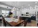 Open-concept dining room with a large table, stylish chandelier, and modern kitchen with white cabinets and stainless steel appliances at 524 Lobelia Dr, Lake Mary, FL 32746
