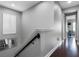 Upstairs hallway with railing, mirror, and access to a room with hardwood floors and natural light at 524 Lobelia Dr, Lake Mary, FL 32746