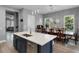 Modern kitchen with island, quartz countertops, stainless steel appliances, and adjacent dining area with view to living room at 524 Lobelia Dr, Lake Mary, FL 32746