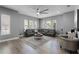 Inviting living room with a large sectional sofa and multiple windows allowing ample sunlight at 524 Lobelia Dr, Lake Mary, FL 32746