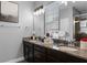 Main bathroom featuring double vanity with granite countertop, decorative mirrors, and a private commode at 524 Lobelia Dr, Lake Mary, FL 32746