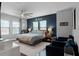 Relaxing main bedroom with large bed, accent wall, ceiling fan, and natural light from multiple windows at 524 Lobelia Dr, Lake Mary, FL 32746