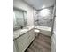 Bathroom featuring granite vanity, white cabinets, and tub with gray marble tiling at 534 Central Ave, Frostproof, FL 33843