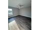 Bedroom featuring wood-look floors, gray walls, ceiling fan, and natural light from the window at 534 Central Ave, Frostproof, FL 33843