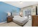 Bright bedroom featuring a tufted headboard, stylish decor, and sliding glass doors to the outdoor patio at 5353 Oakbourne Ave, Davenport, FL 33837
