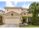 Charming two-story home features a tile roof, two car garage and mature landscaping at 5353 Oakbourne Ave, Davenport, FL 33837