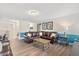 Spacious living room with hardwood floors, plush leather seating, and ample natural light for comfortable living at 5353 Oakbourne Ave, Davenport, FL 33837