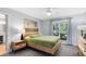 Bright bedroom with a wooden bed frame, decorative wall art, and a large window offering backyard views at 5370 Whispering Pine Cir, St Cloud, FL 34771