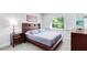 Comfortable bedroom with a platform bed, matching nightstand and dresser, and backyard views at 5370 Whispering Pine Cir, St Cloud, FL 34771