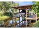 Picturesque boat dock with a boat lift, adjacent to a furnished deck and overlooking tranquil waters at 5370 Whispering Pine Cir, St Cloud, FL 34771