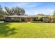 Charming single-story home featuring a well-manicured lawn, stone accents, and an inviting orange front door at 5370 Whispering Pine Cir, St Cloud, FL 34771