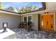 Cozy front porch with seating area, an orange entry door, and stylish paving at 5370 Whispering Pine Cir, St Cloud, FL 34771