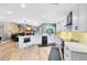Modern kitchen with white cabinets, stainless steel appliances, and open layout to living areas at 5370 Whispering Pine Cir, St Cloud, FL 34771