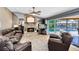 Cozy living room with a stone fireplace, comfortable leather furniture, and a view of the screened-in pool area at 5370 Whispering Pine Cir, St Cloud, FL 34771